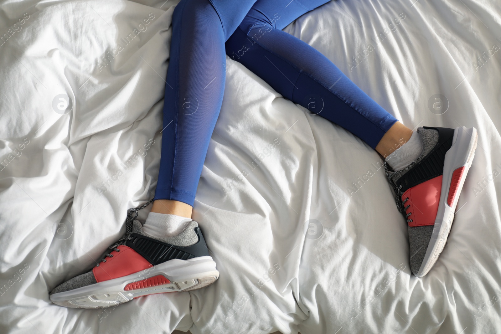 Photo of Lazy young woman sleeping on bed instead of morning training, closeup