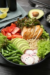 Photo of Healthy meal. Tasty products in bowl on black wooden table, closeup