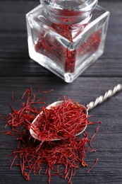 Photo of Dried saffron on black wooden table, closeup