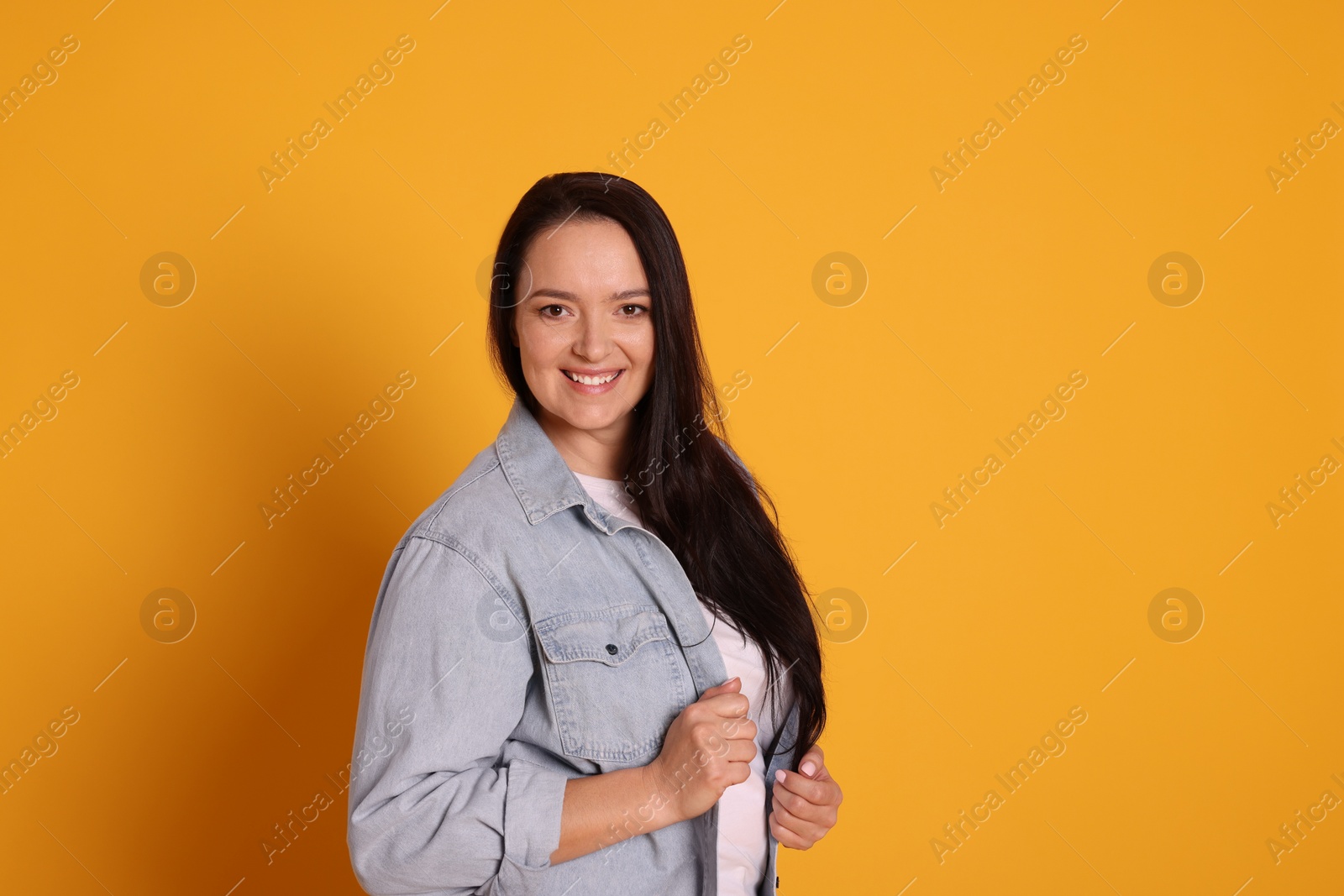 Photo of Beautiful overweight woman with charming smile on yellow background. Space for text