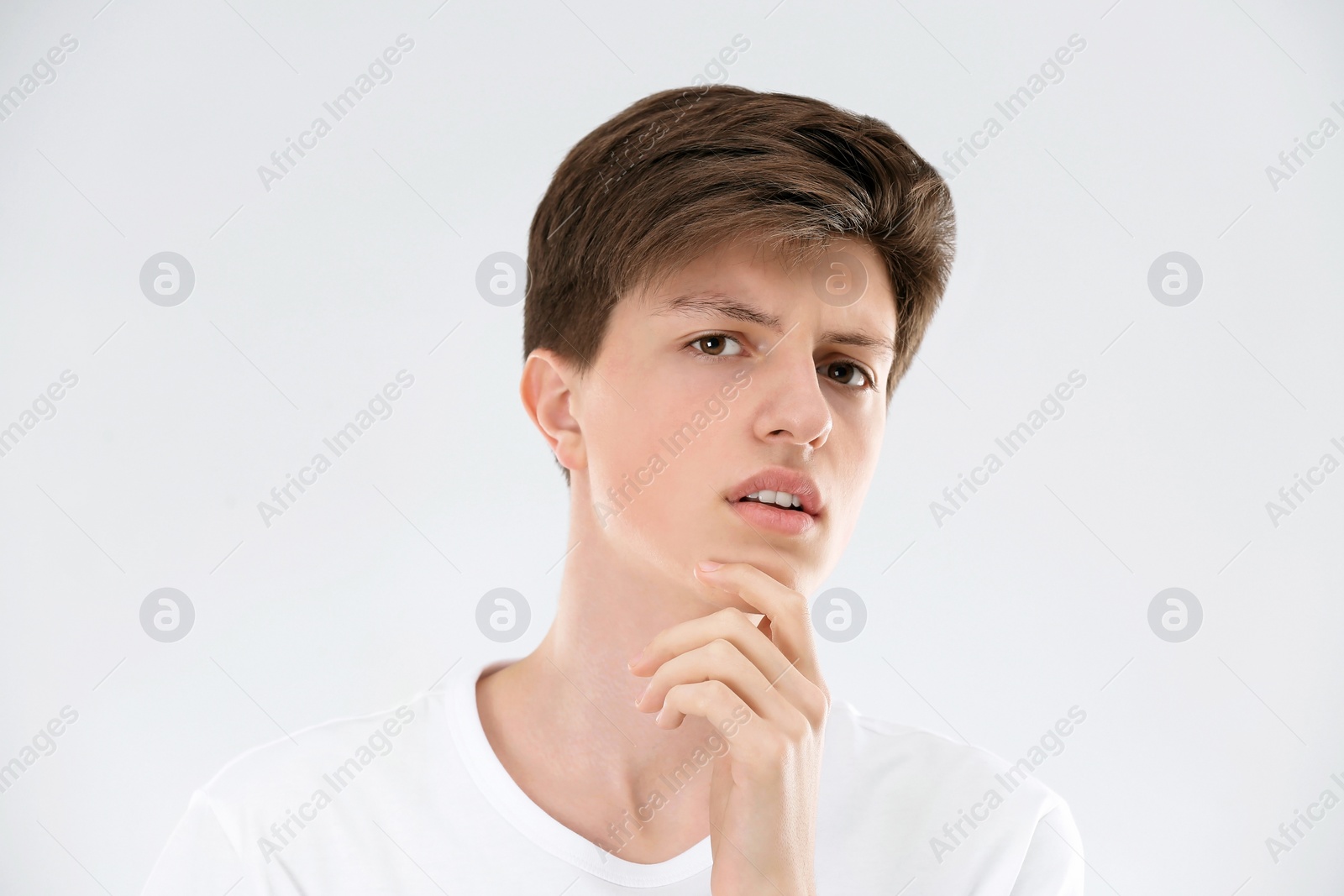 Photo of Teenage boy with acne problem on light background