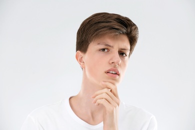 Teenage boy with acne problem on light background