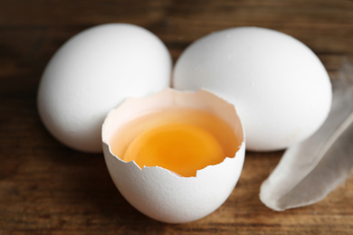 Photo of Fresh raw chicken eggs on wooden table, closeup