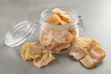 Delicious dried jackfruit slices on light grey table