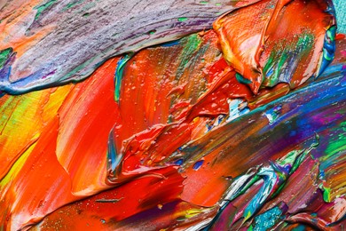 Photo of Strokes of colorful acrylic paints as background, closeup view