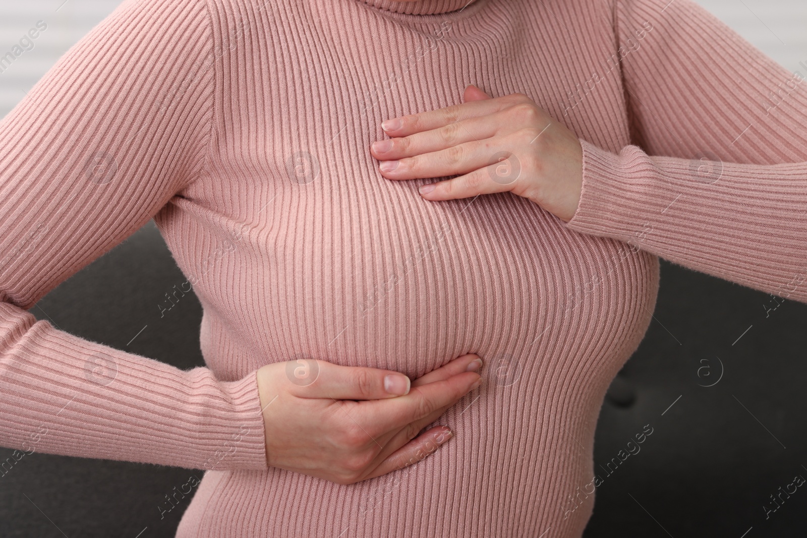 Photo of Mammology. Woman doing breast self-examination indoors, closeup