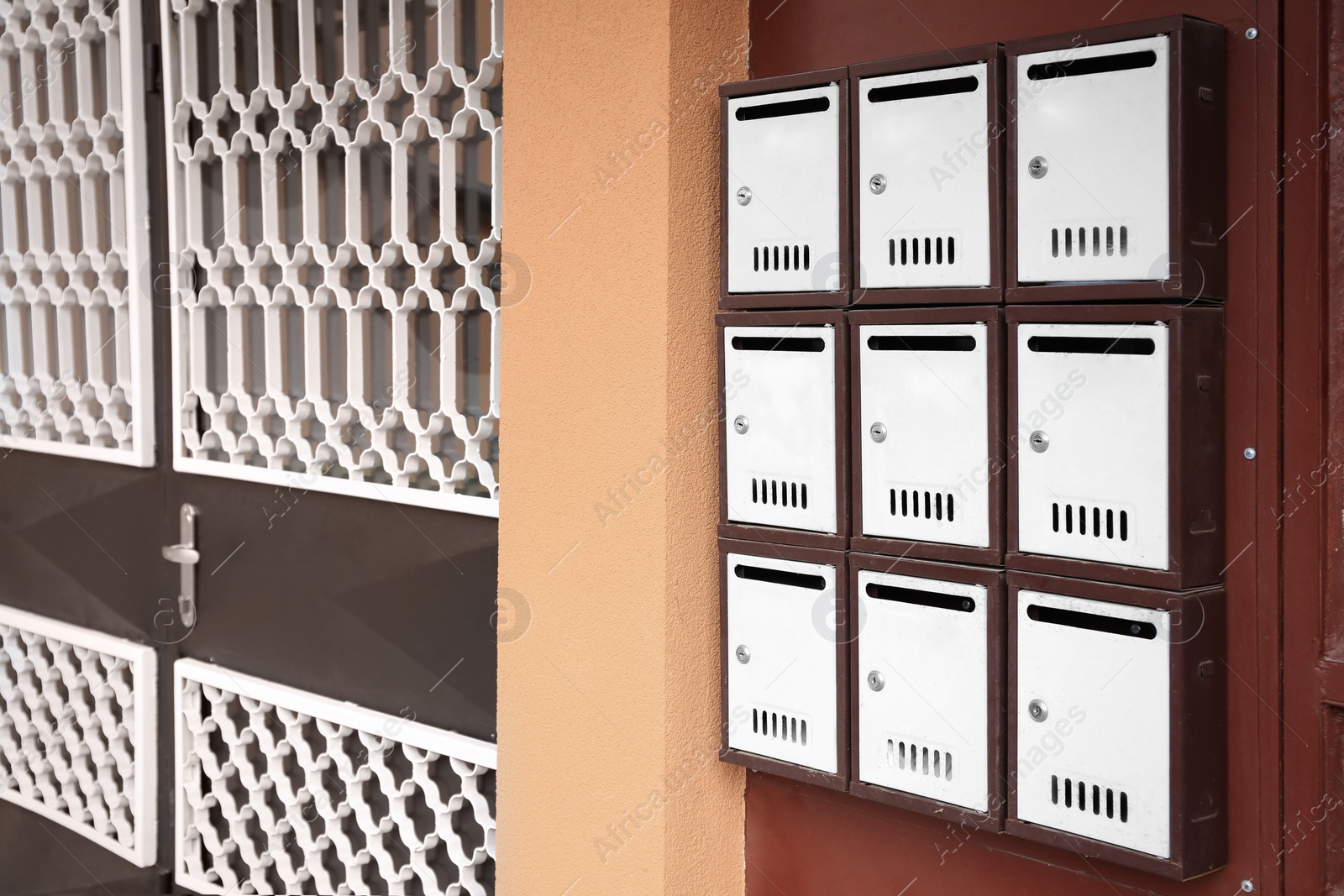 Photo of Many metal letter boxes on door outdoors