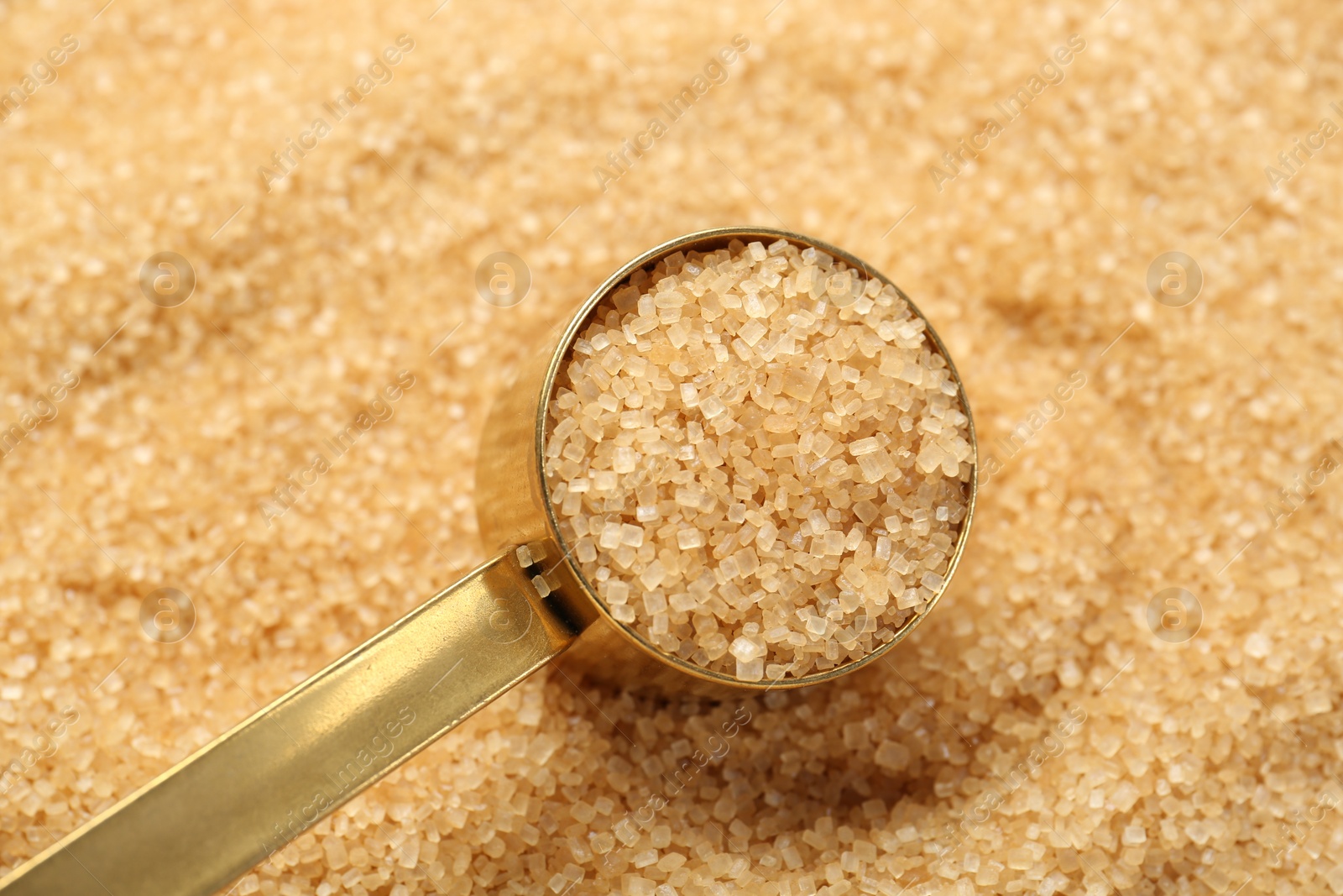 Photo of Scoop on granulated brown sugar, closeup view