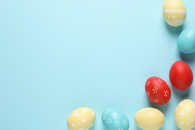 Photo of Flat lay composition with painted Easter eggs on color background, space for text