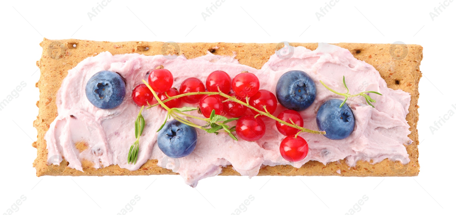 Photo of Tasty crispy cracker with cream cheese, thyme and berries isolated on white, top view