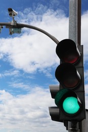 Photo of Modern traffic light in city against cloudy sky