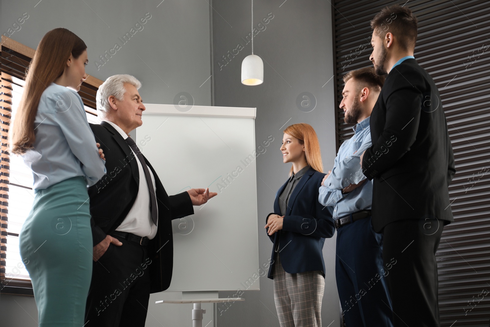 Photo of Senior business trainer working with people in office