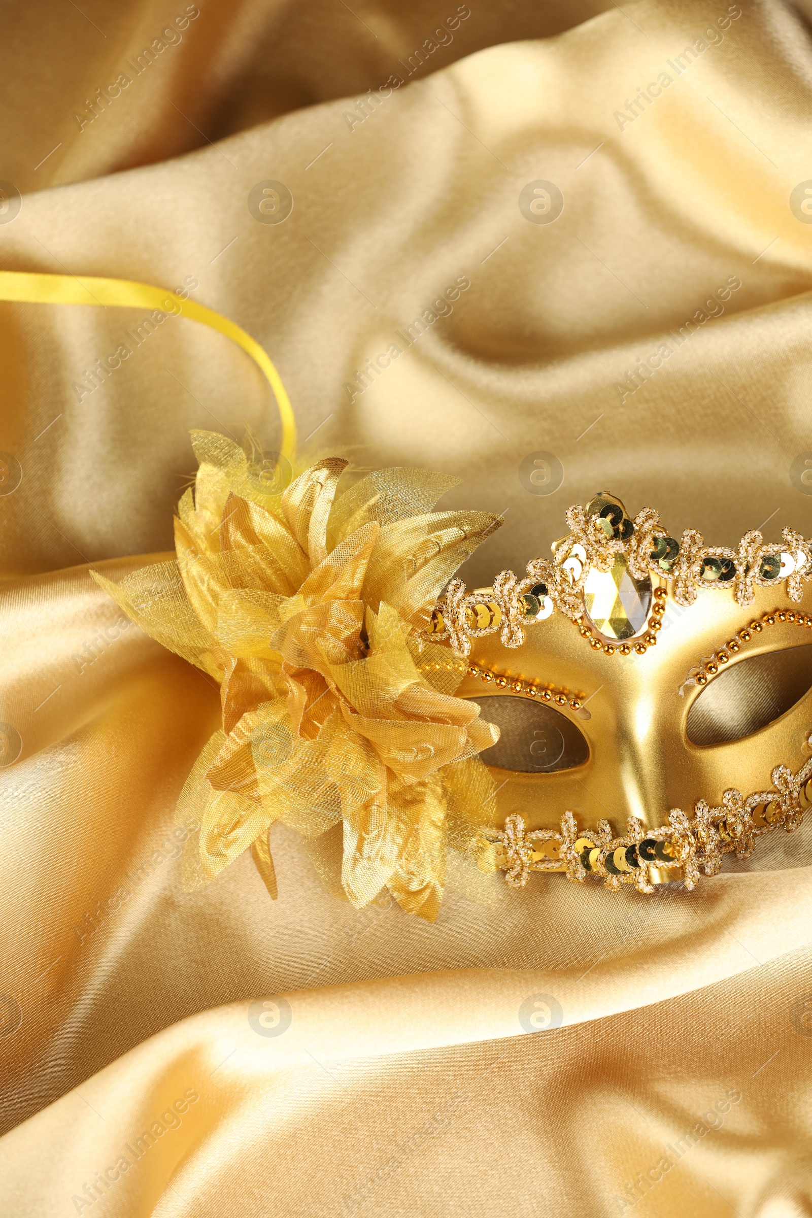 Photo of Beautifully decorated face mask on golden fabric. Theatrical performance