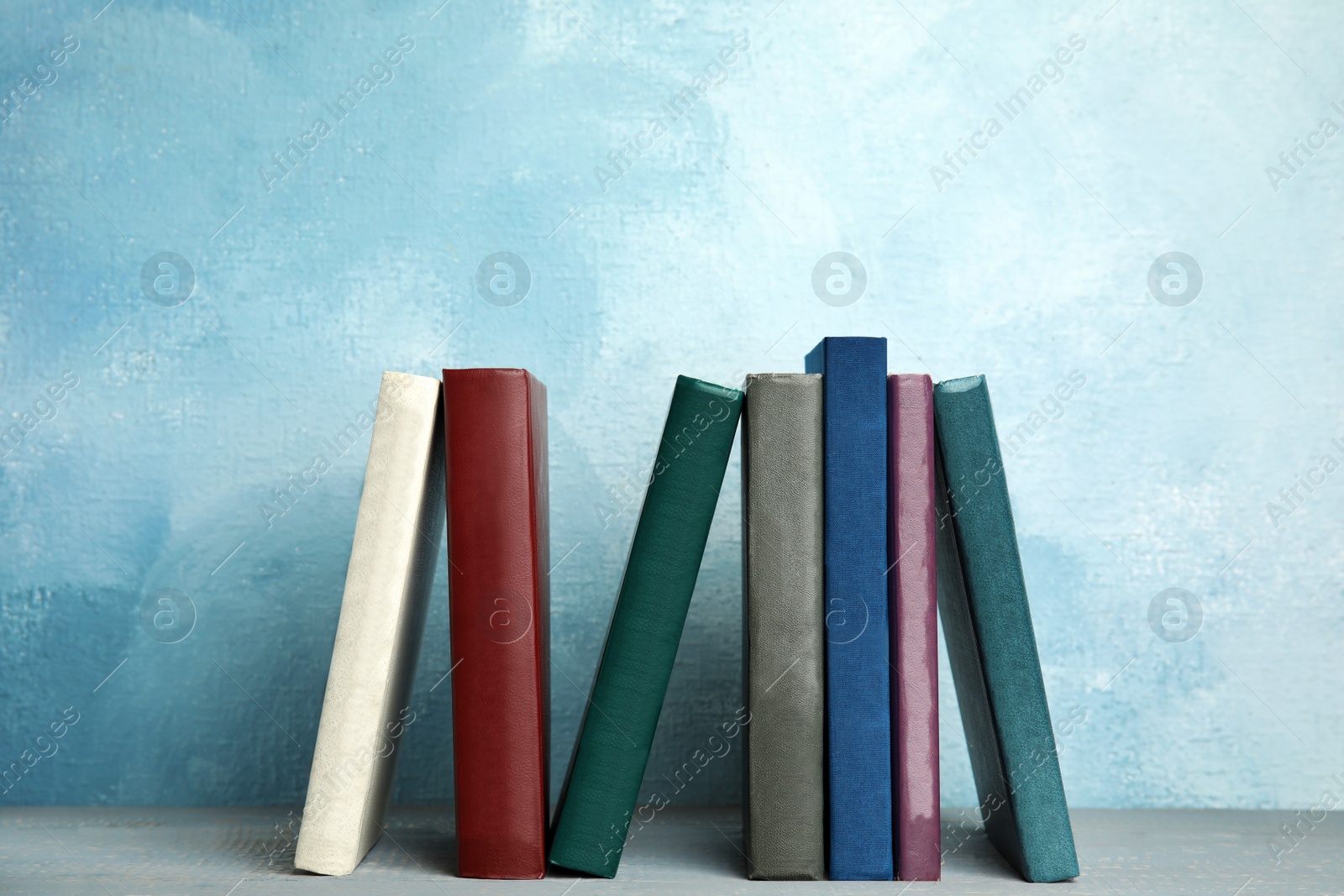 Photo of Collection of old books on grey wooden shelf