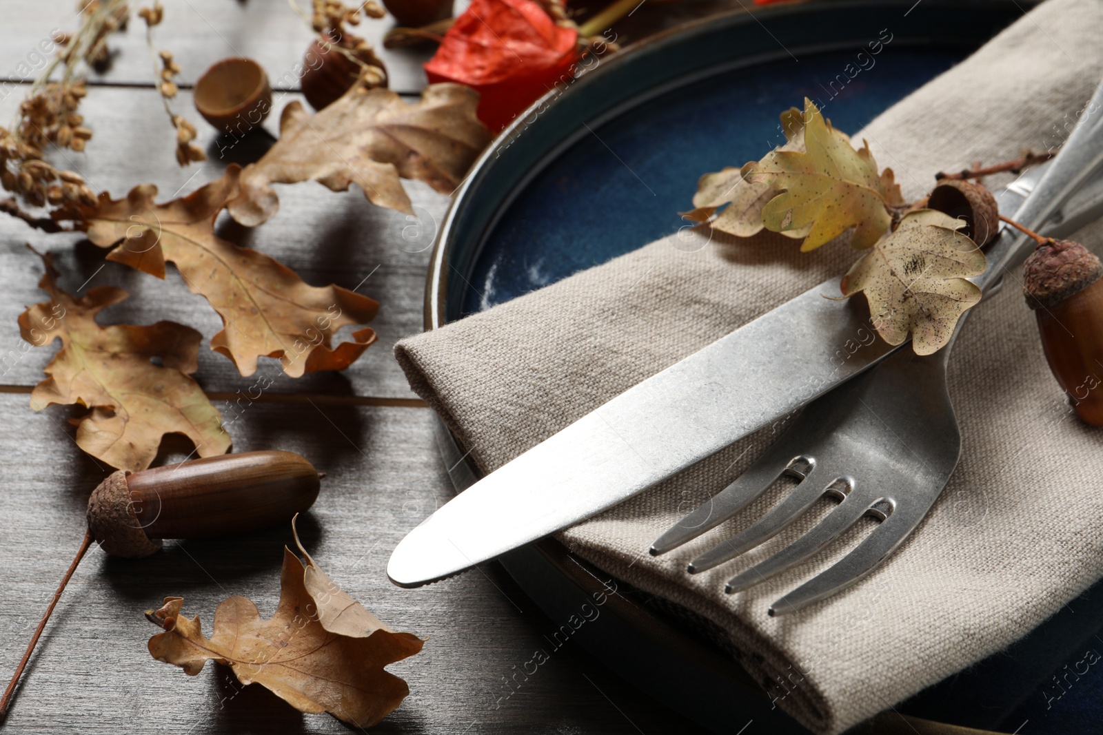 Photo of Festive table setting with autumn decor on wooden background, closeup