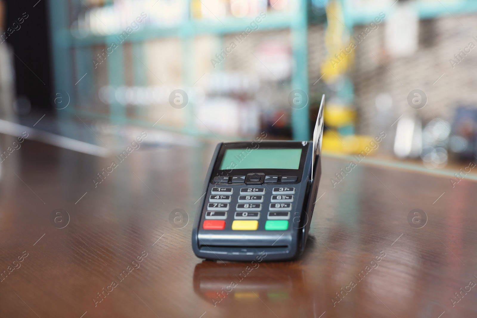 Photo of Credit card machine for non cash payment on wooden counter in cafe. Space for text