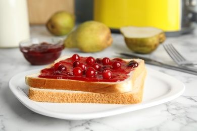 Slice of bread with jam on white marble table