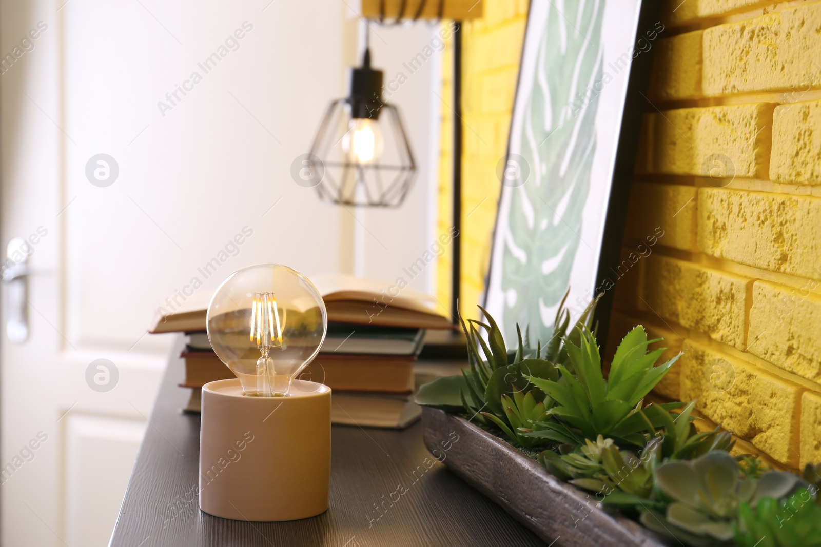 Photo of Modern night lamp, houseplants and decor on table in room