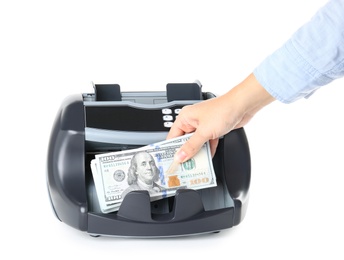 Woman putting money into counting machine on white background, closeup