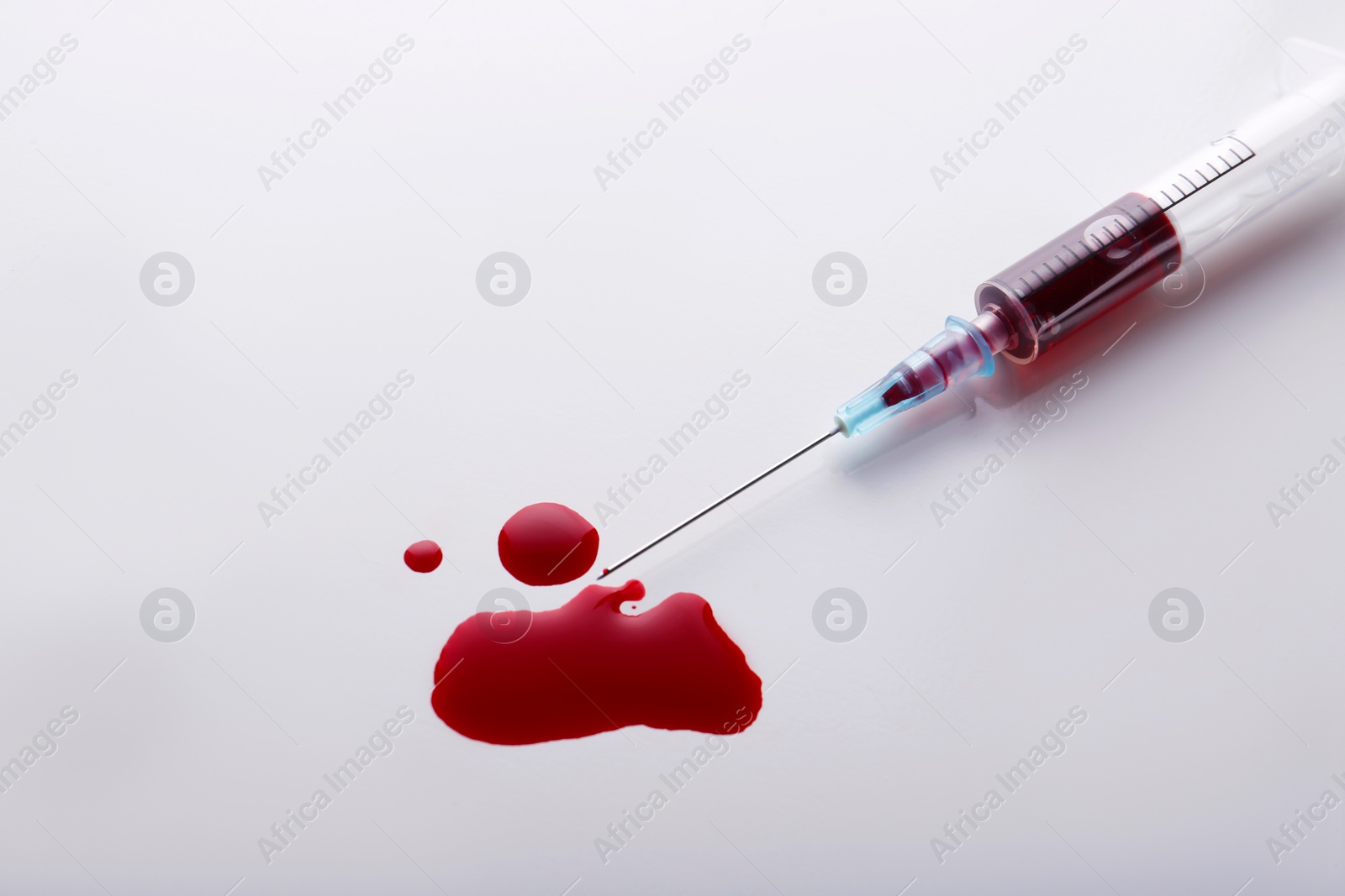 Photo of Plastic syringe with blood on white background