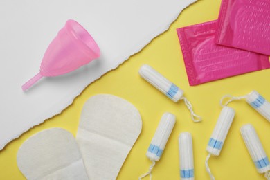 Photo of Reusable and disposable menstrual hygiene products on color background, flat lay