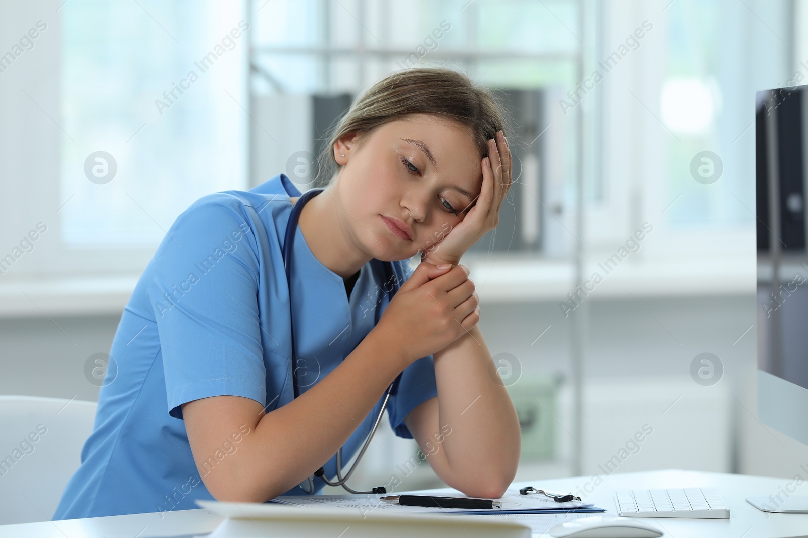 Photo of Exhausted doctor sleeping at workplace in hospital