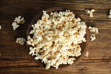 Photo of Tasty pop corn on wooden table, flat lay