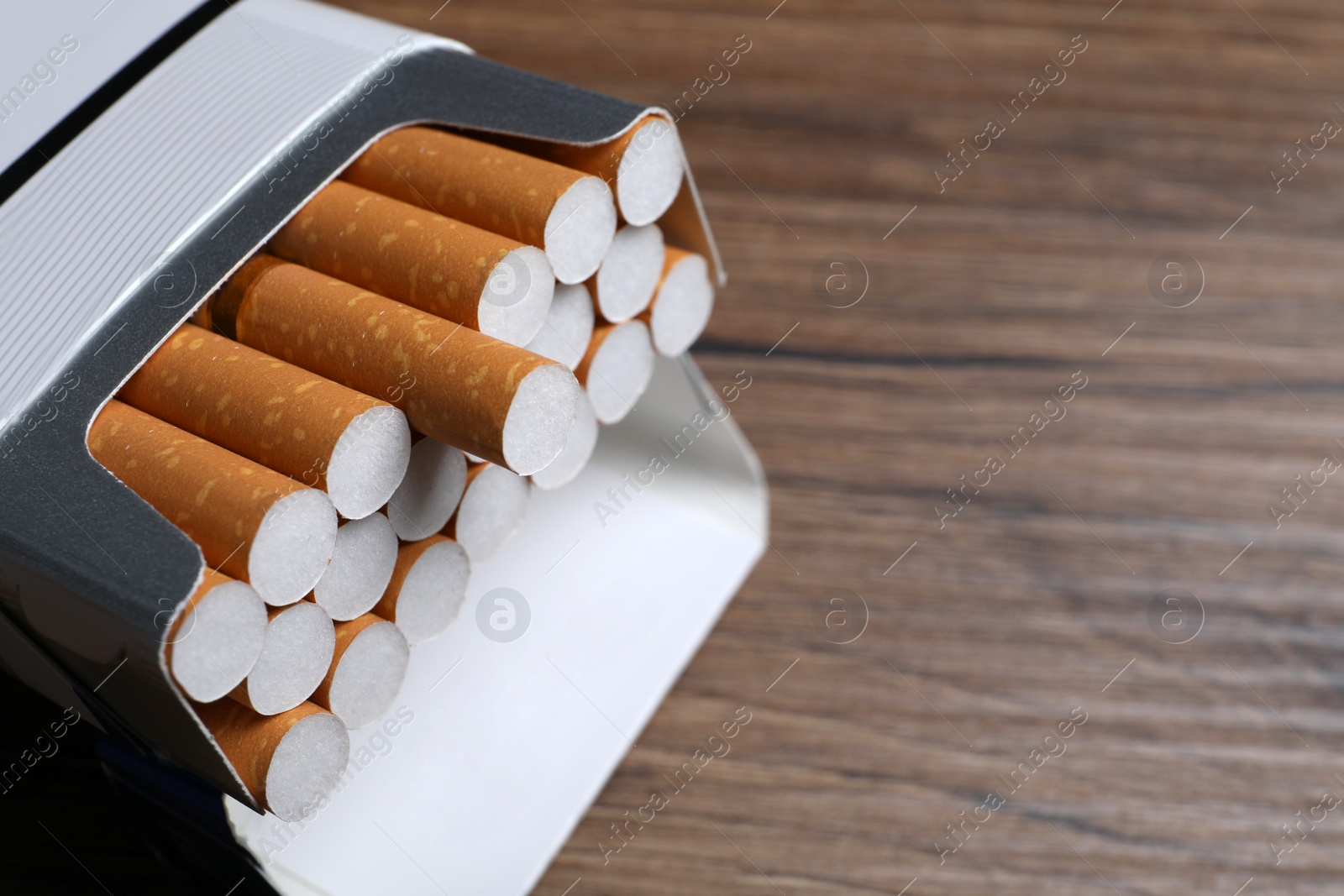 Photo of Cigarettes in pack on table, closeup. Space for text