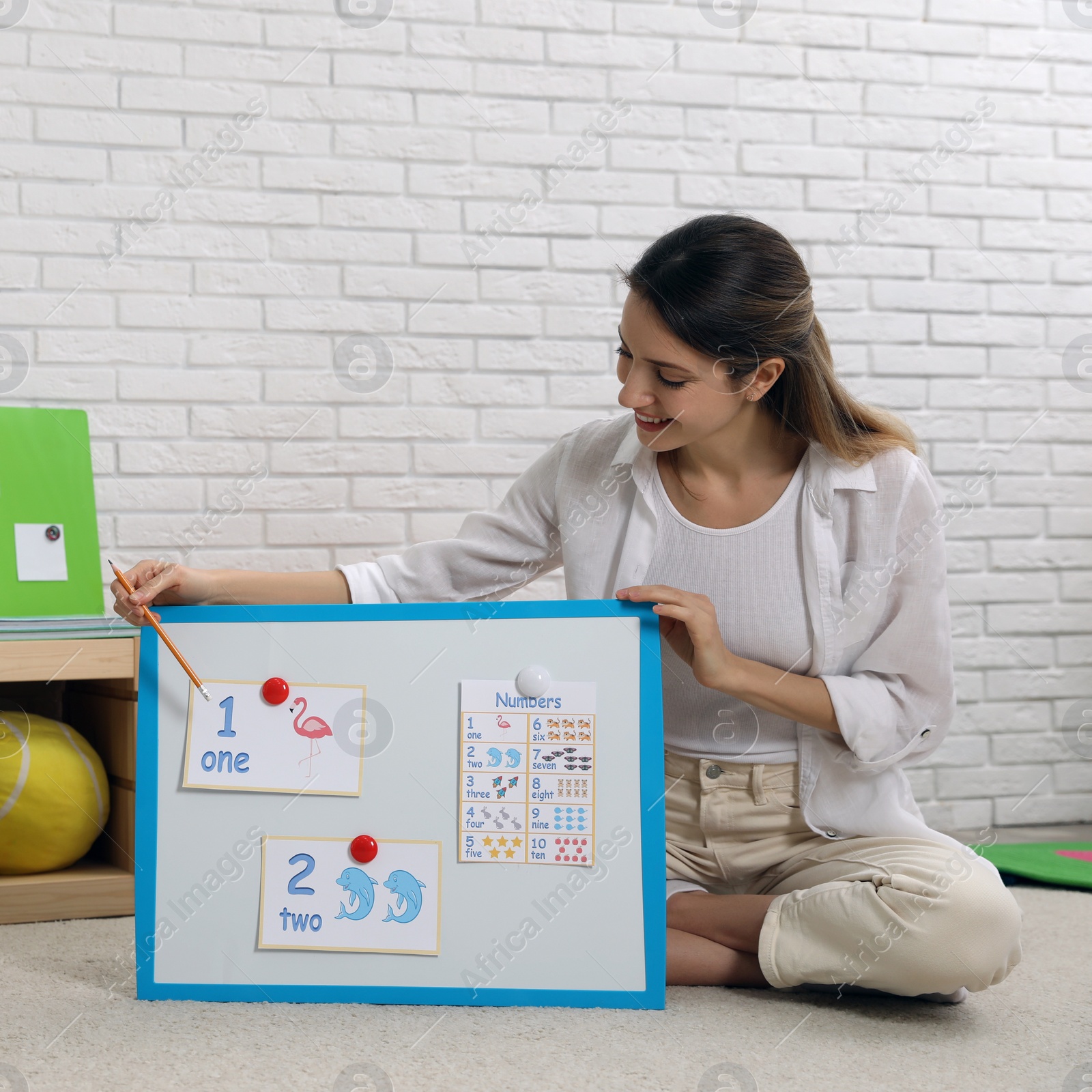 Photo of Happy female English teacher giving lesson in elementary school