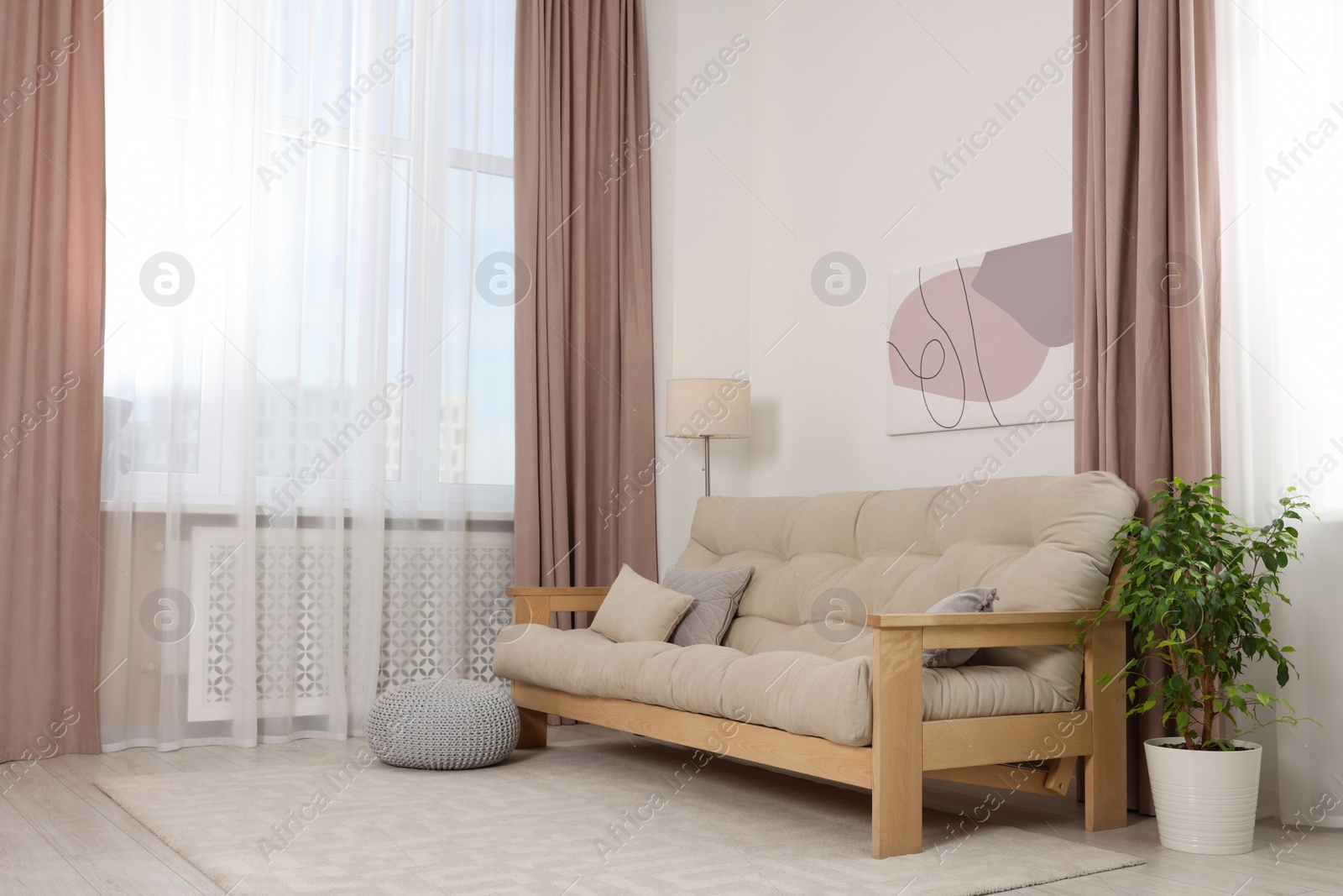 Photo of Stylish room interior with comfortable sofa, houseplant and elegant curtains