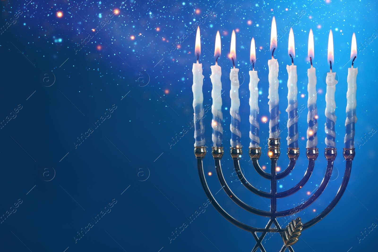 Image of Hanukkah celebration. Menorah with burning candles on blue background, closeup. Space for text
