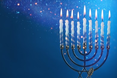 Hanukkah celebration. Menorah with burning candles on blue background, closeup. Space for text