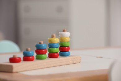 Stacking and counting game wooden pieces on table indoors, space for text. Educational toy for motor skills development