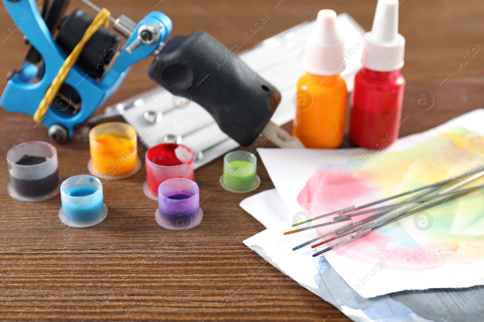 Photo of Composition with tattoo needles on wooden table