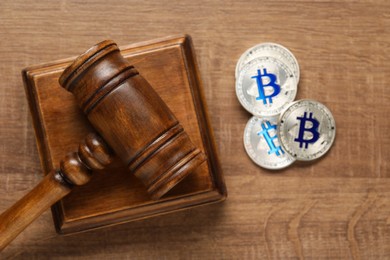Photo of Law concept. Gavel and bitcoins on wooden table, top view