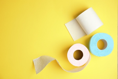 Toilet paper rolls on color background, top view. Space for text