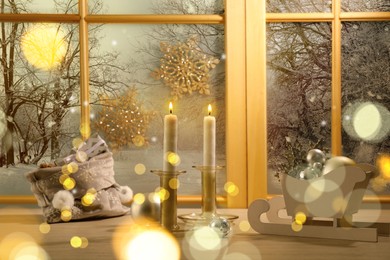Image of Burning candles, bag with gift boxes and festive decor on window sill indoors. Christmas eve