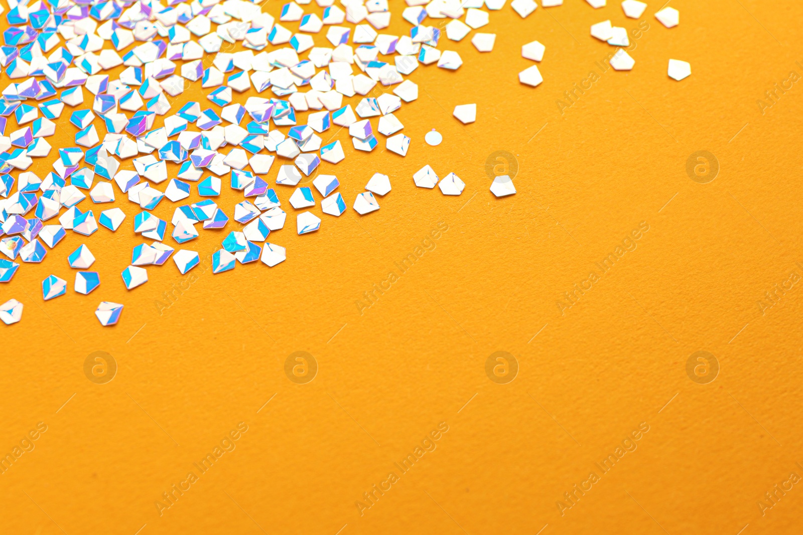 Photo of Shiny bright light glitter on orange background. Space for text