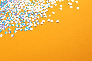 Photo of Shiny bright light glitter on orange background. Space for text