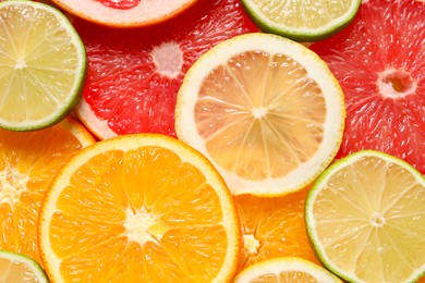 Photo of Different sliced citrus fruits as background, top view