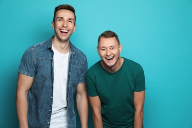 Photo of Man laughing with his friend against color background
