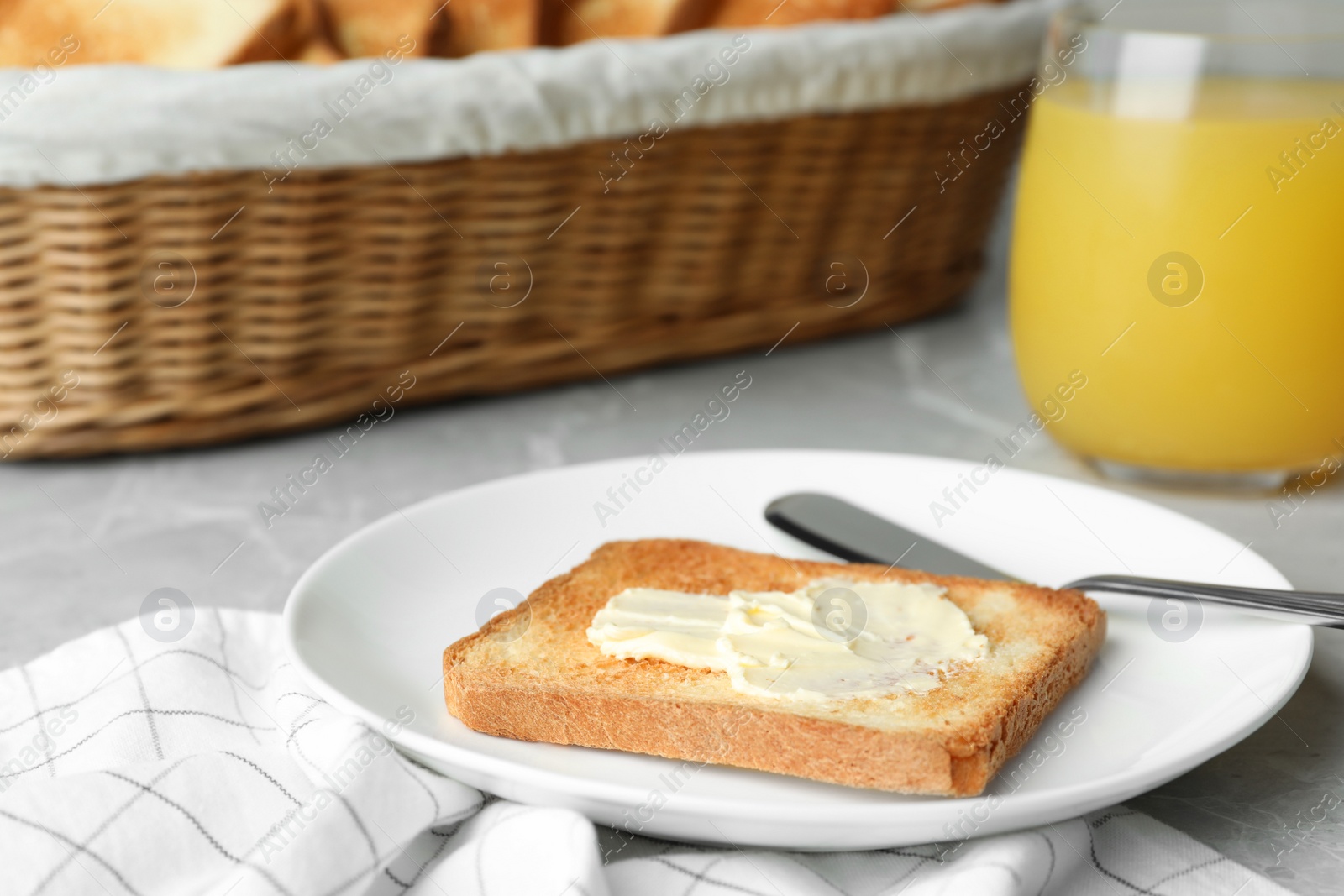 Photo of Slice of toasted bread with butter on grey table