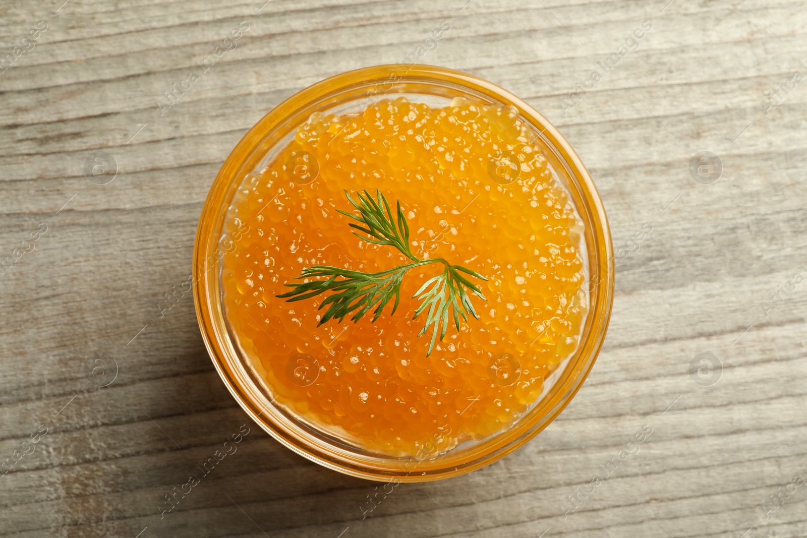 Photo of Fresh pike caviar in bowl on wooden table, top view