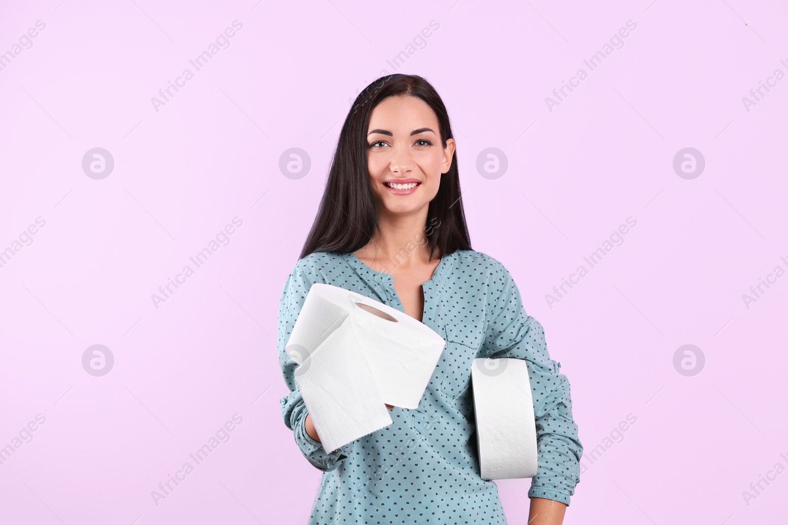 Photo of Beautiful woman holding toilet paper rolls on color background