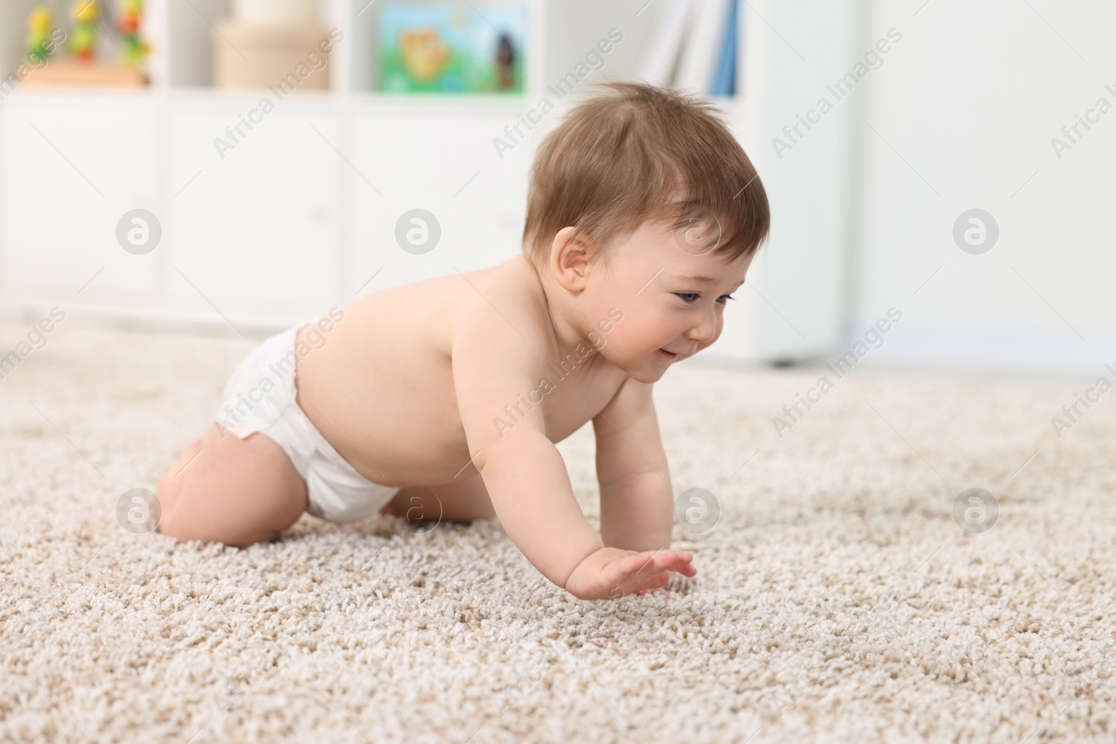 Photo of Cute baby boy crawling on carpet at home