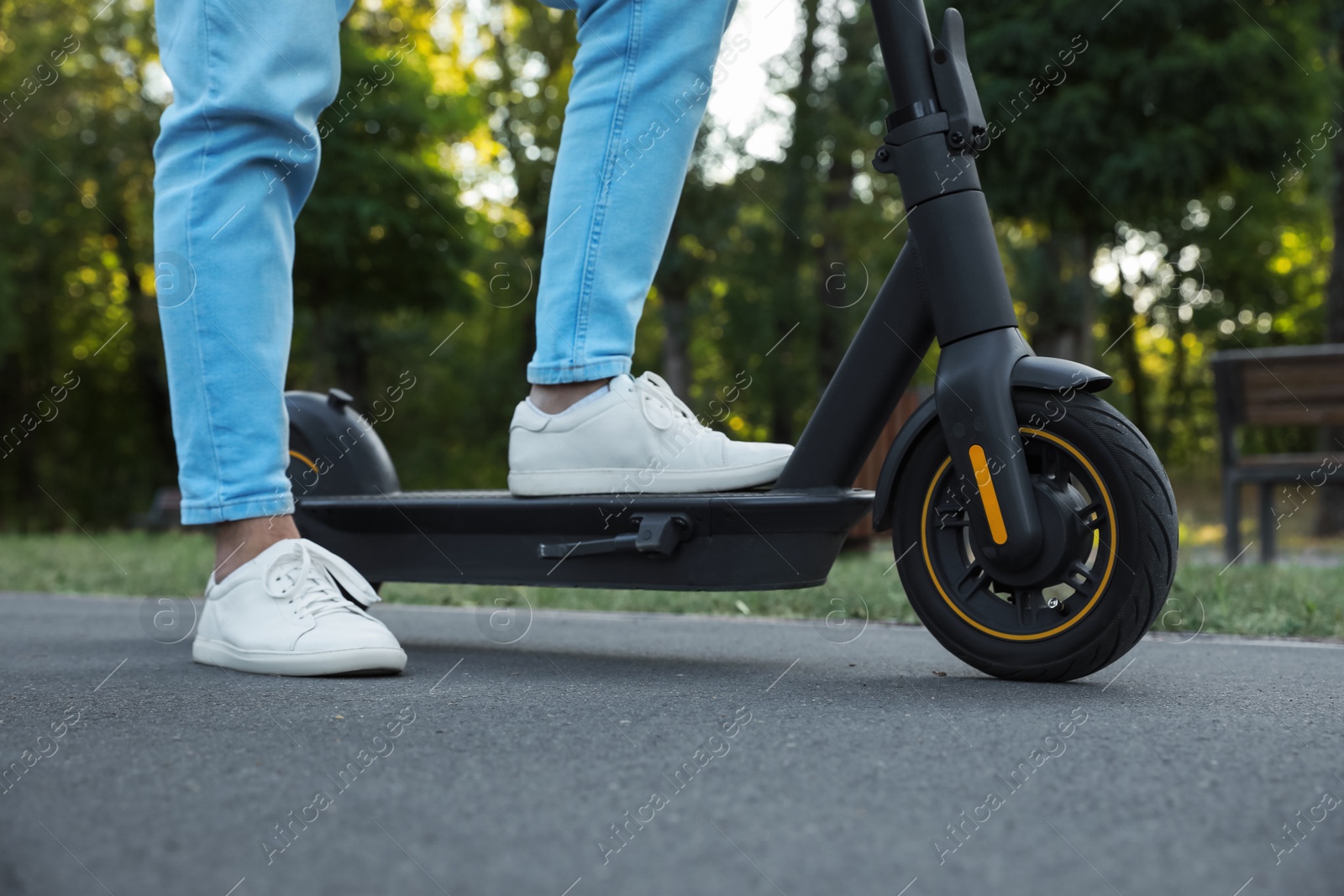 Photo of Man with modern electric kick scooter in park, closeup