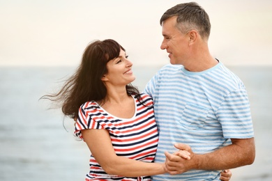 Happy mature couple spending time together on sea beach