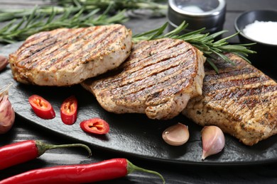 Photo of Delicious grilled pork steaks with spices on table, closeup