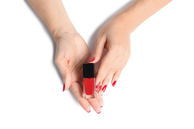 Woman with bright manicure holding bottle of nail polish on white background, closeup