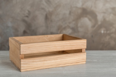 Photo of Wooden crate on table against color background. Space for text